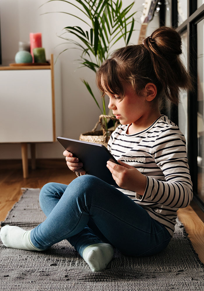 portrait-girl-jeans-sitting-carpet-bedroom-playing-tablet